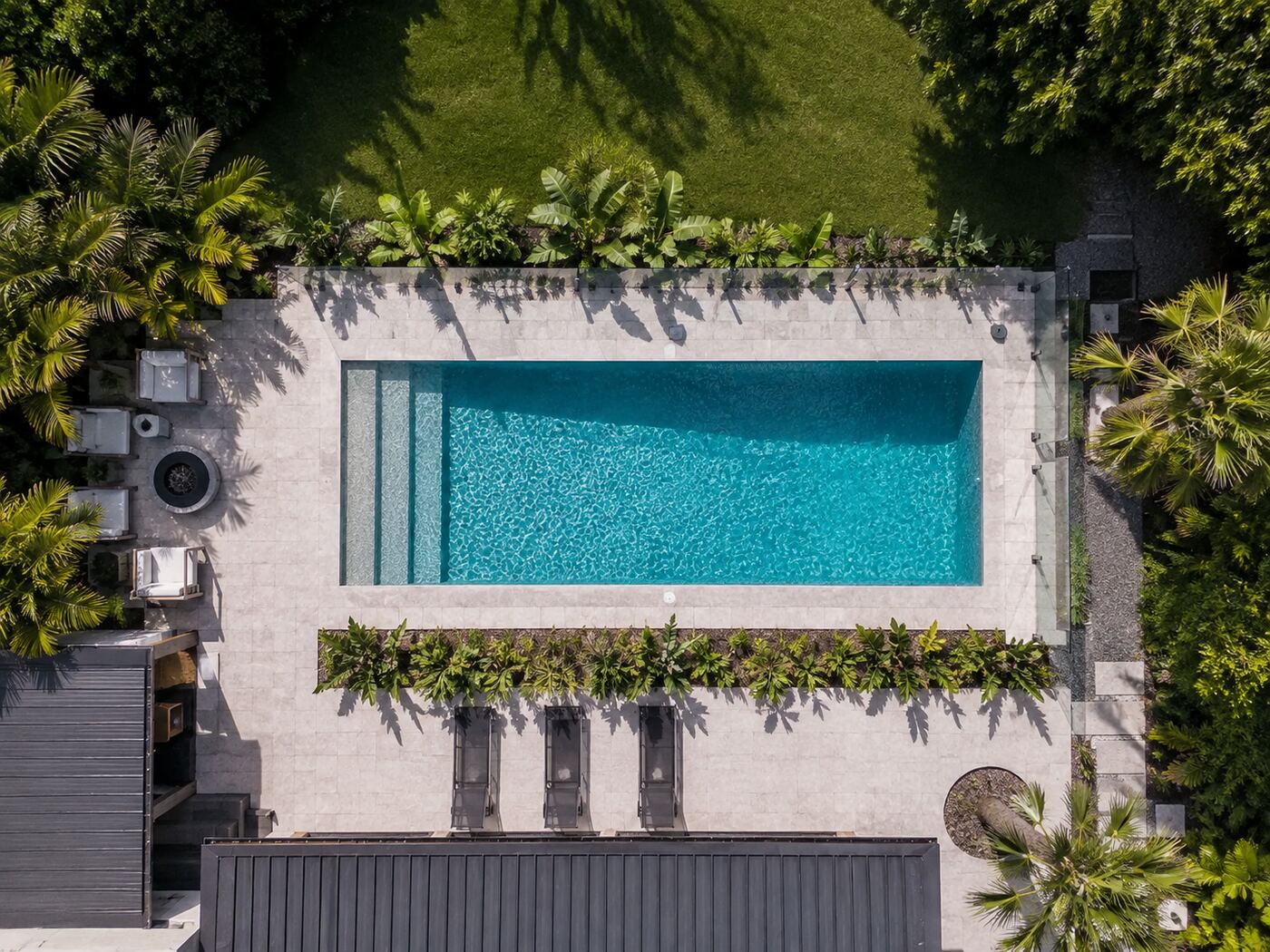 Aerial view of a backyard pool with compliant glass barrier before a pre-sale inspection